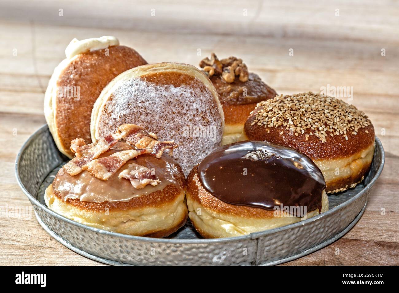 Tablett mit verschiedenen gefüllten Donuts mit verschiedenen Belägen und Glasur Stockfoto