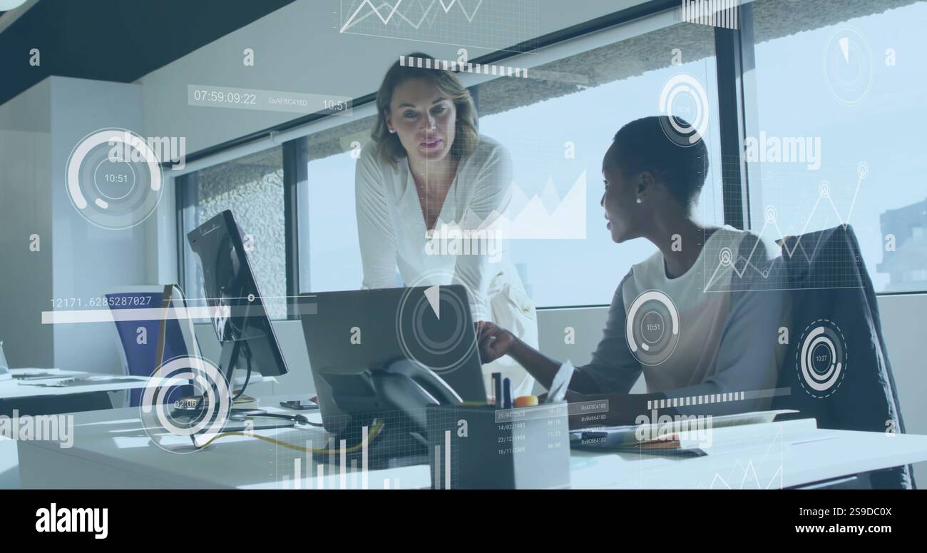 Bild der Analyse von Geschäftsdaten über zwei Frauen, die über die Arbeit in modernen Büros diskutieren Stockfoto