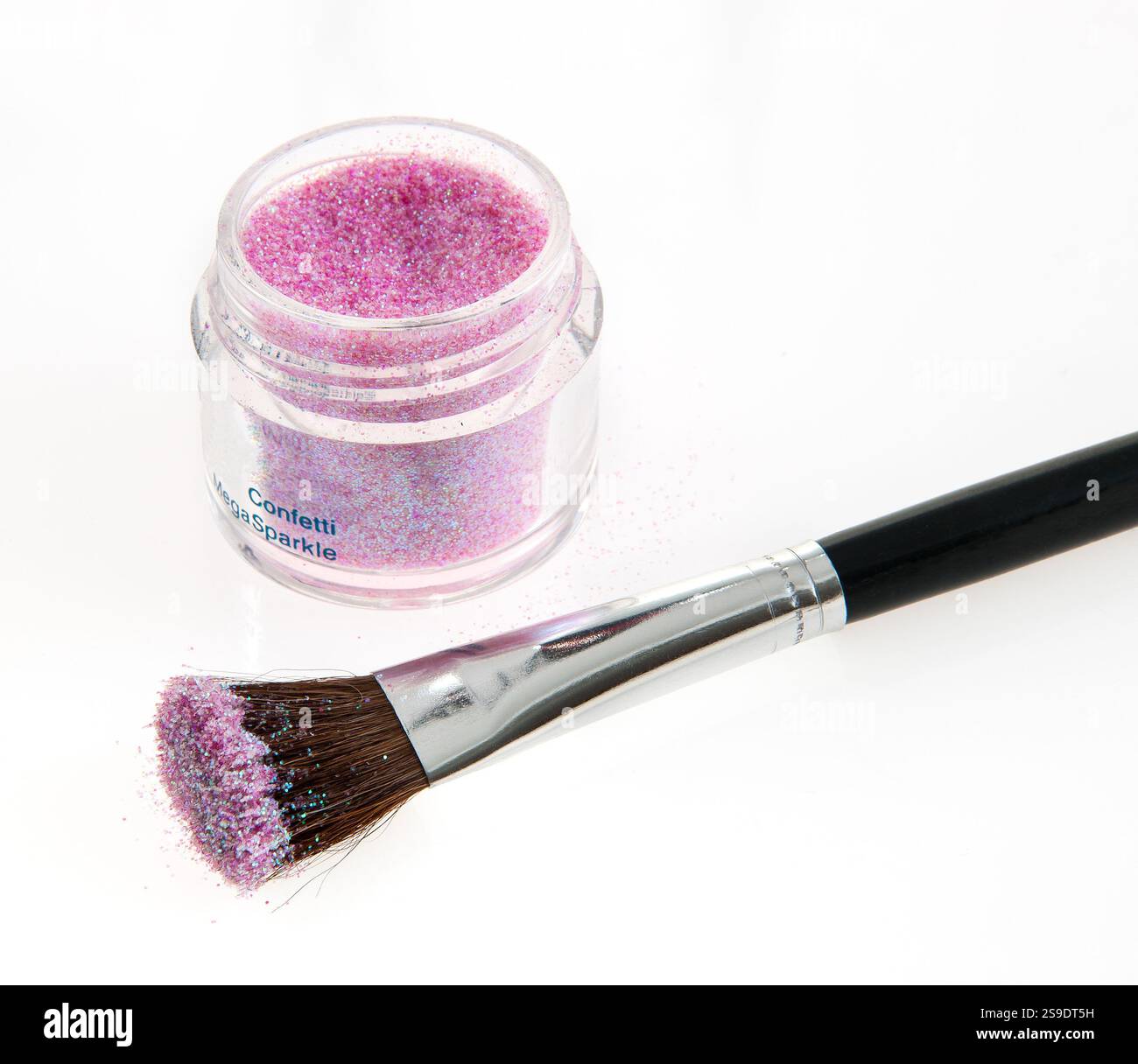 Violettes Glitzerpigment und schwarzer Schminkpinsel auf einem sauberen, weißen Hintergrund, die Elemente der Schönheit, Kreativität und Kosmetik darstellen Stockfoto