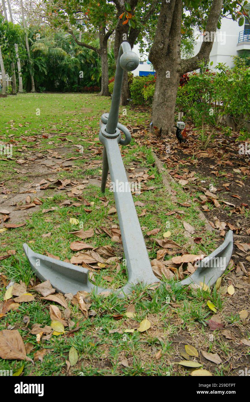 Vertikale Ansicht großer Anker auf grünem Gras. Bäume und Pflanzen im Hintergrund. Keine Leute und Platz zum Kopieren. Stockfoto