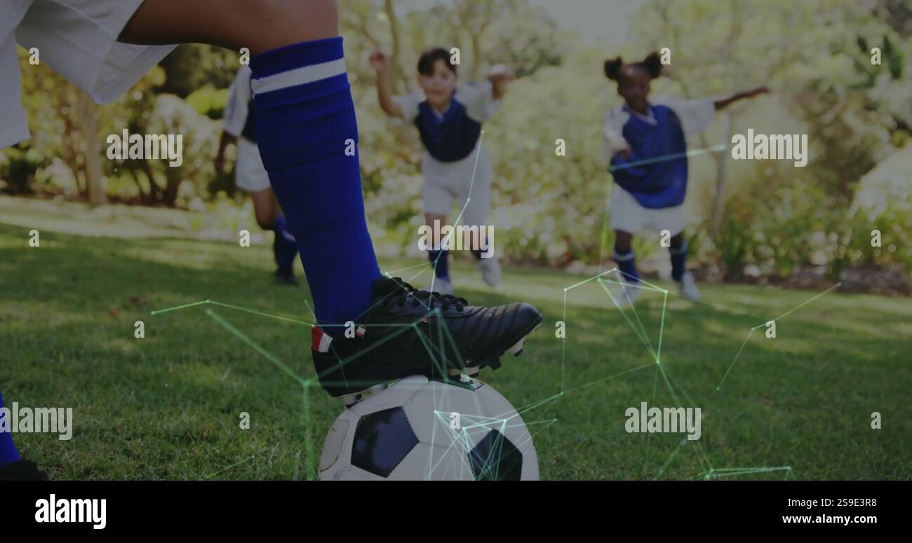 Fußball spielen, Kinder in blauen Uniformen mit Netzwerkverbindungen sehen darüber Stockfoto
