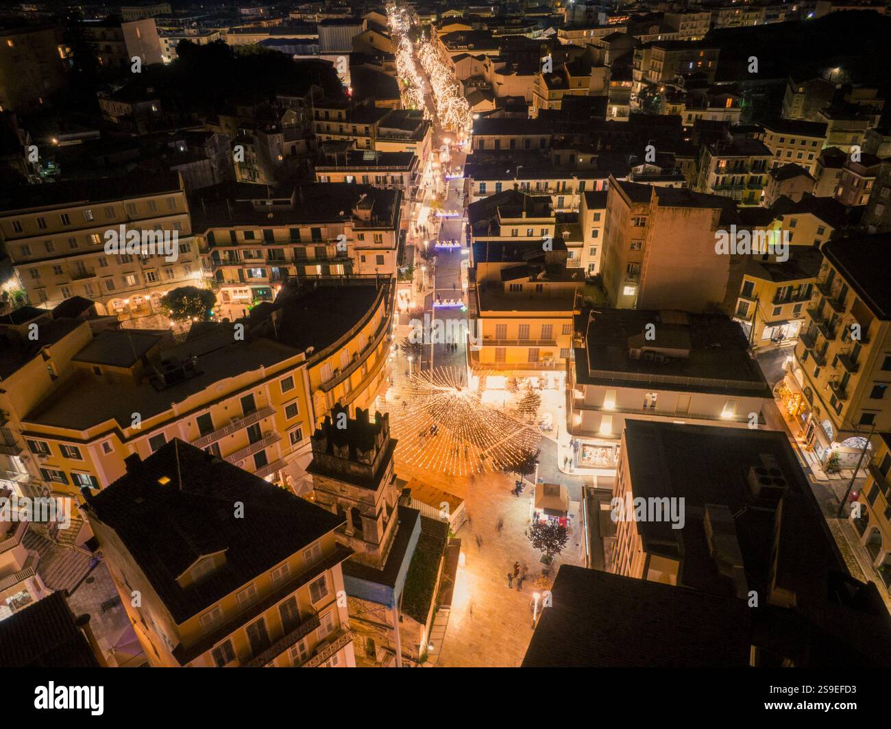 Luftaufnahme einer Stadtstraße bei Nacht, beleuchtet mit warmen Lichtern. Stockfoto
