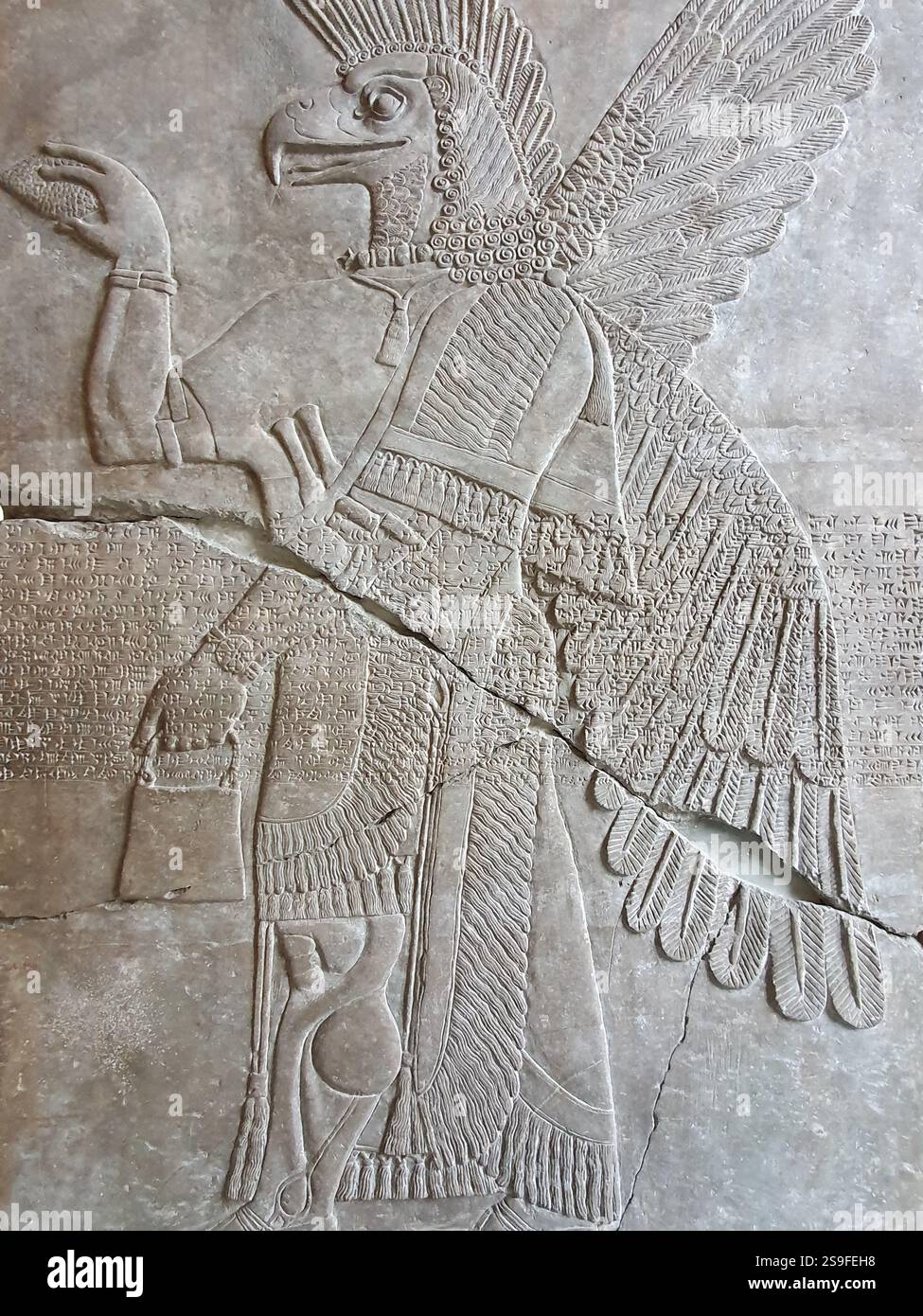 Der Reliefstich des mesopotamischen Flügeladlergottes Apkallu oder Abgal ziert die Wände eines alten assyrischen Tempels. Stockfoto