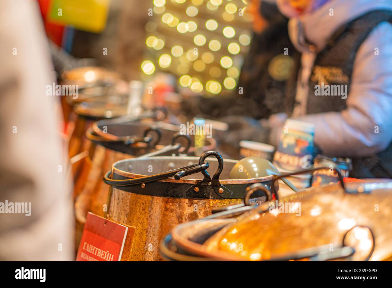 Ein lebhafter Lebensmittelmarkt oder eine Messe-Szene, mit verschiedenen Töpfen, die über Feuer gekocht werden, und farbenfrohen Lichtern, die eine festliche Atmosphäre verleihen. Zwei Personen können s sein Stockfoto