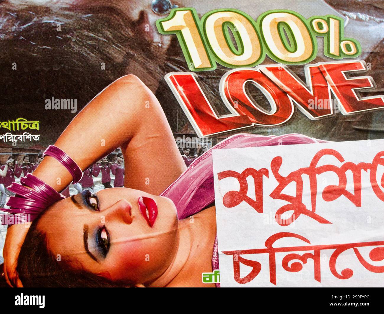 Romantisches Dhallywood-Filmplakat für 100 % Liebe, ausgestellt auf einer Dhaka-Straße, mit dramatischen Ausdrücken, leidenschaftlichen Posen und lebhaften Farben. Stockfoto