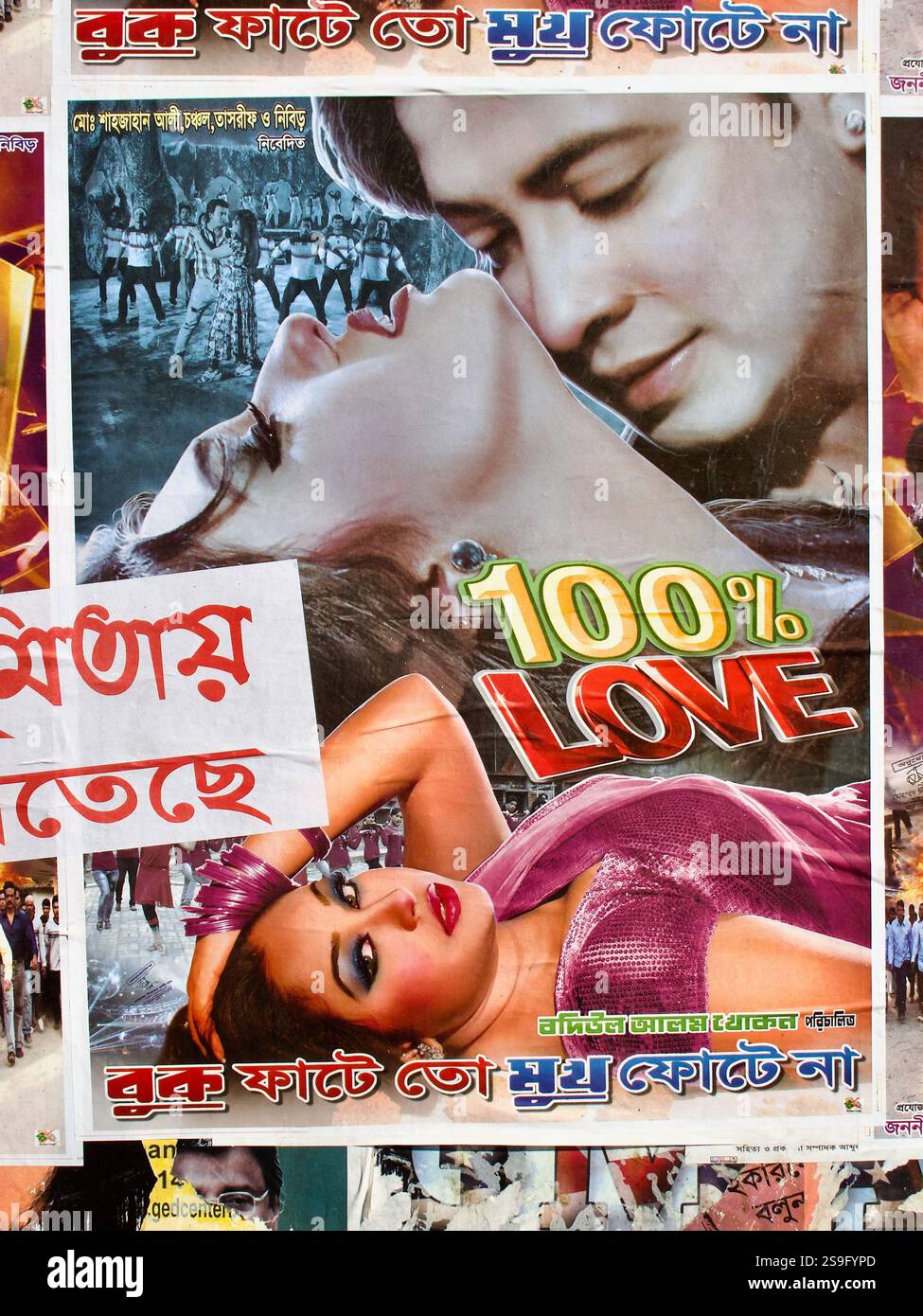 Romantisches Dhallywood-Filmplakat für 100 % Liebe, ausgestellt auf einer Dhaka-Straße, mit dramatischen Ausdrücken, leidenschaftlichen Posen und lebhaften Farben. Stockfoto