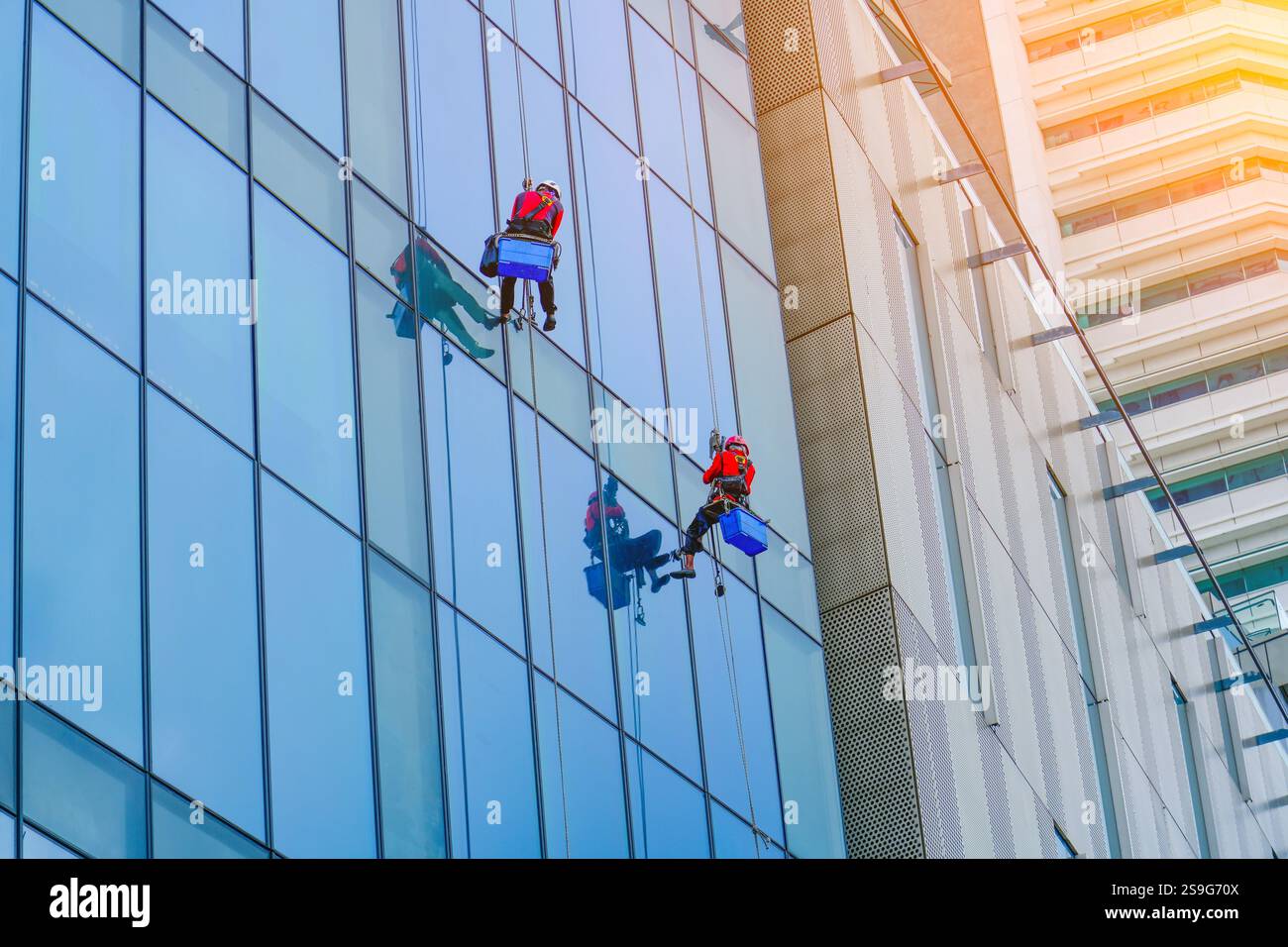 Arbeiten Sie in der Höhe. Bergsteigen in der Industrie, Gruppe von Arbeitern, die Fenster reinigen, Service in Hochhäusern Stockfoto