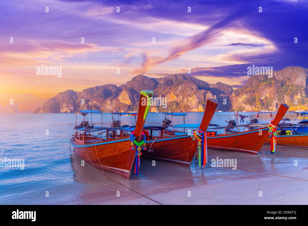 Longtail Boote am wunderschönen Strand Thailand früh morgens bei Sonnenaufgang wunderschöne Wolken über der Haibucht im Ozean. Stockfoto