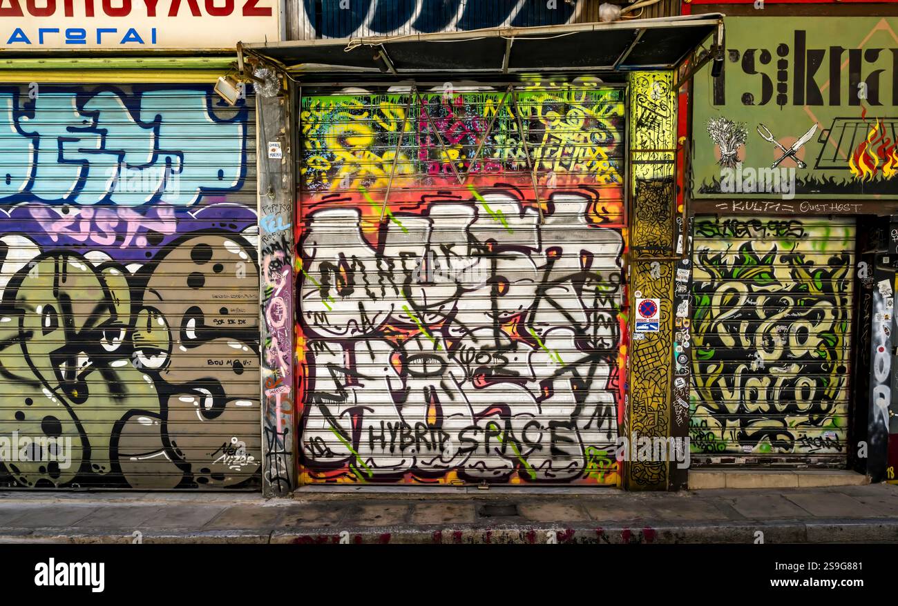 Urbane Graffiti bedecken die pulsierenden Wände und Ladenfronten einer Stadtallee und zeigen Straßenkultur und künstlerischen Ausdruck. Stockfoto