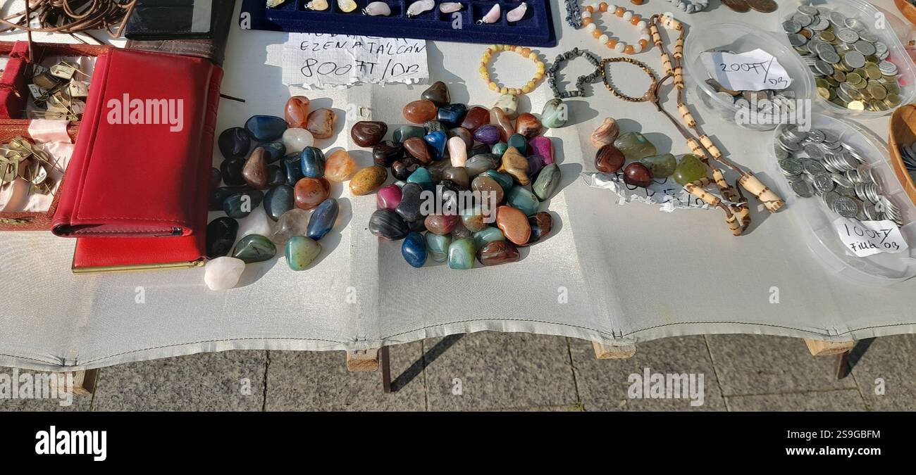 Europäischer Antiquitätenmarkt, Stand am Flohmarkt : farbenfrohe Kristallsteine, Kristallschmuck, Bernsteinketten, Vintage-Spielzeug, Vintage-Bücher, Vintage Rosenkranzperlen , Naturstein und Mineralien Halsketten, Edelstein Anhänger, Vintage Medaillen, Kristallarmbänder, , Vintage Modeschmuck, Vintage Münzen Stockfoto