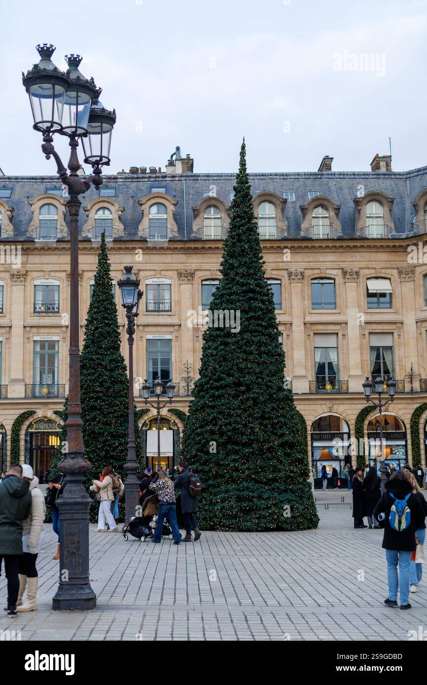 Große Weihnachtsbäume und historische Architektur am Place Vendôme in Paris während der Weihnachtszeit mit Menschen und festlicher Dekoration. Stockfoto Große Weihnachtsbäume und historische Architektur am Place Vendôme in Paris während der Weihnachtszeit mit Menschen und festlicher Dekoration. Stockfoto