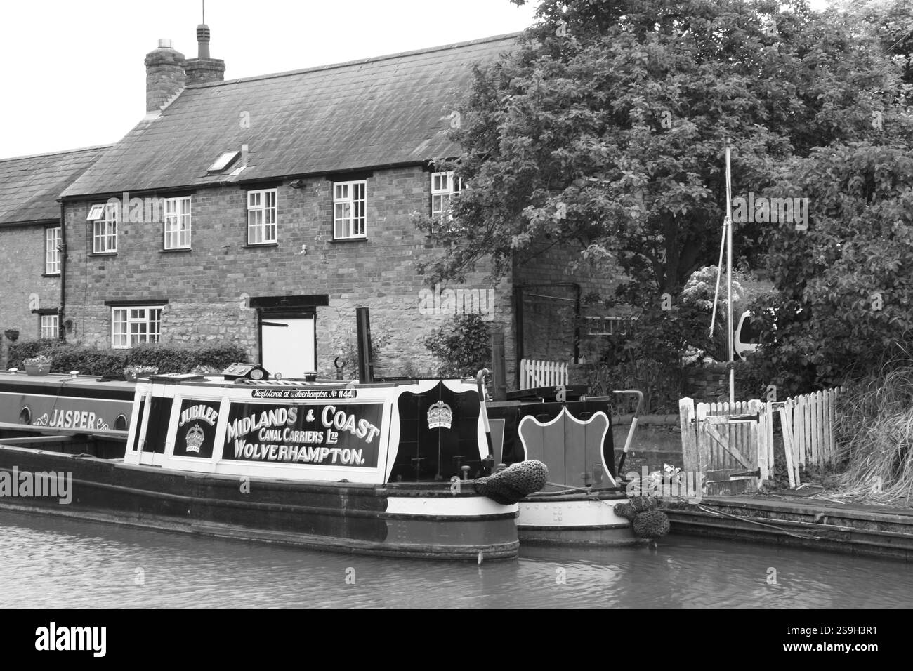 Ein Paar historischer, funktionierender Kanal-Schmalboot auf dem Grand Union Kanal in Stoke bruerne Northamptonshire, das neben alten Kanalhütten vor Anker liegt Stockfoto