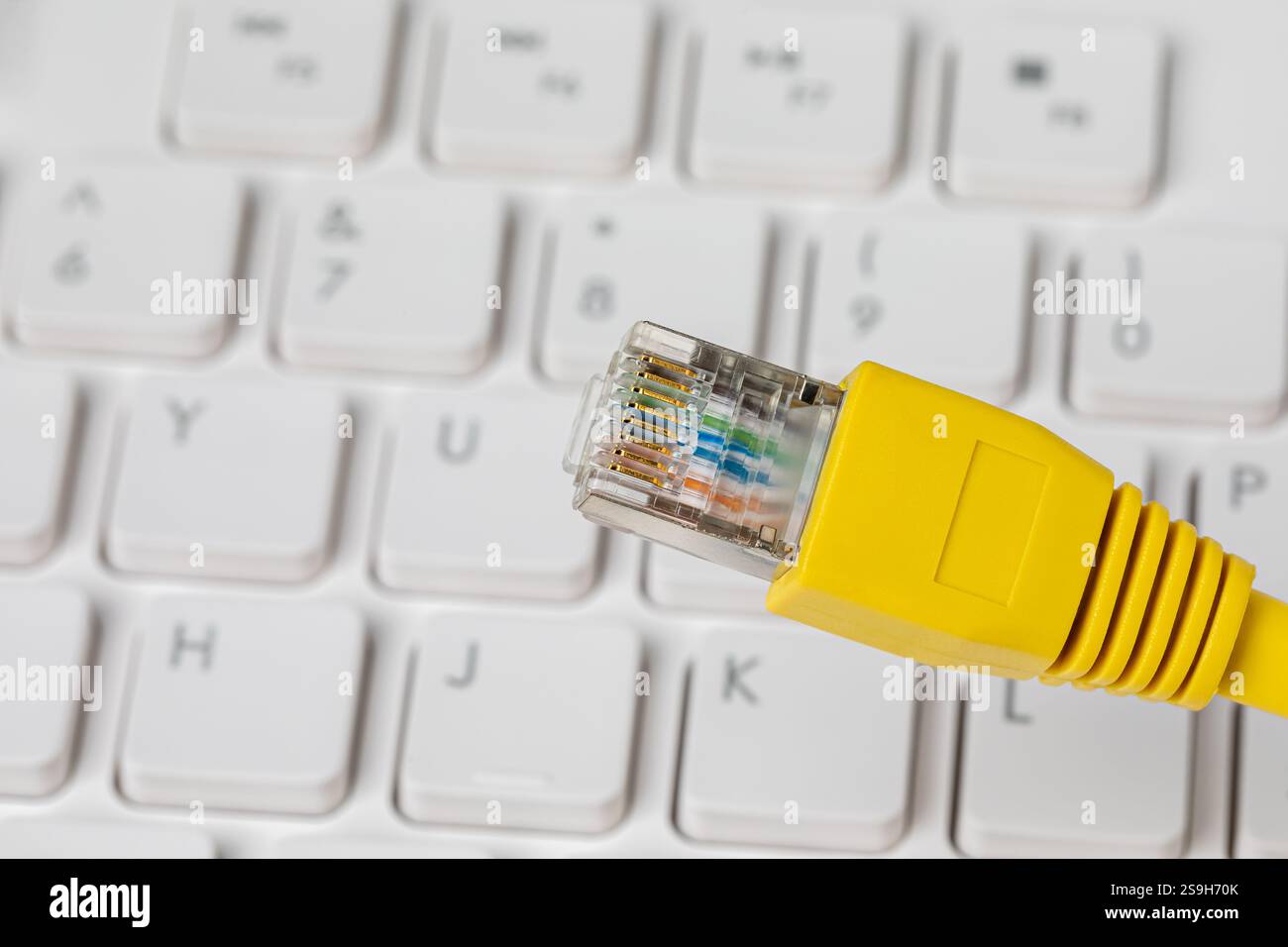 Ethernet-Kabel und Computertastatur. LAN-Netzwerk, Datenübertragungsgeschwindigkeit und Internetverbindungskonzept. Stockfoto