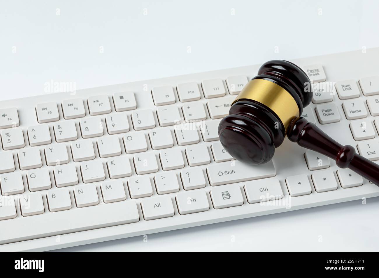Hamel und Tastatur auf weißem Hintergrund isoliert. Konzept für Online-Auktionen, Cybersicherheit und Internet-Regulierung. Stockfoto