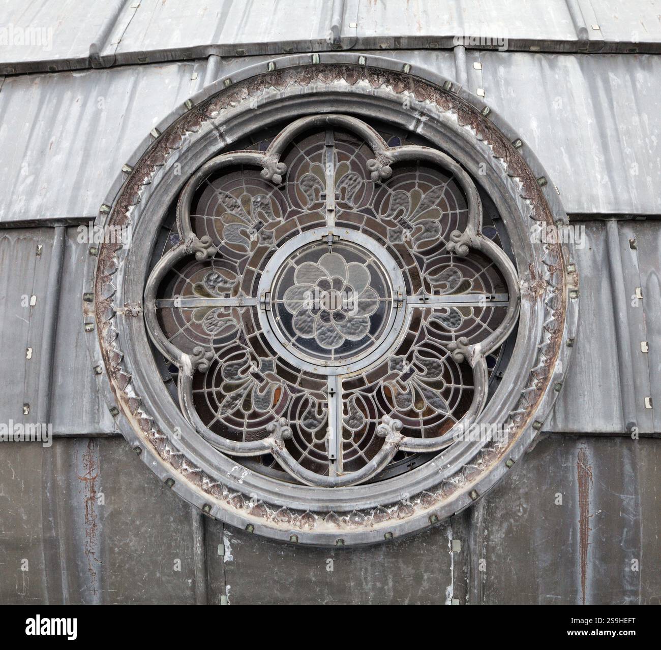 Das aufwändige Design von Buntglasfenstern zeigt Kunstfertigkeit und Handwerkskunst in einem historischen Gebäude in Lourdes. Stockfoto