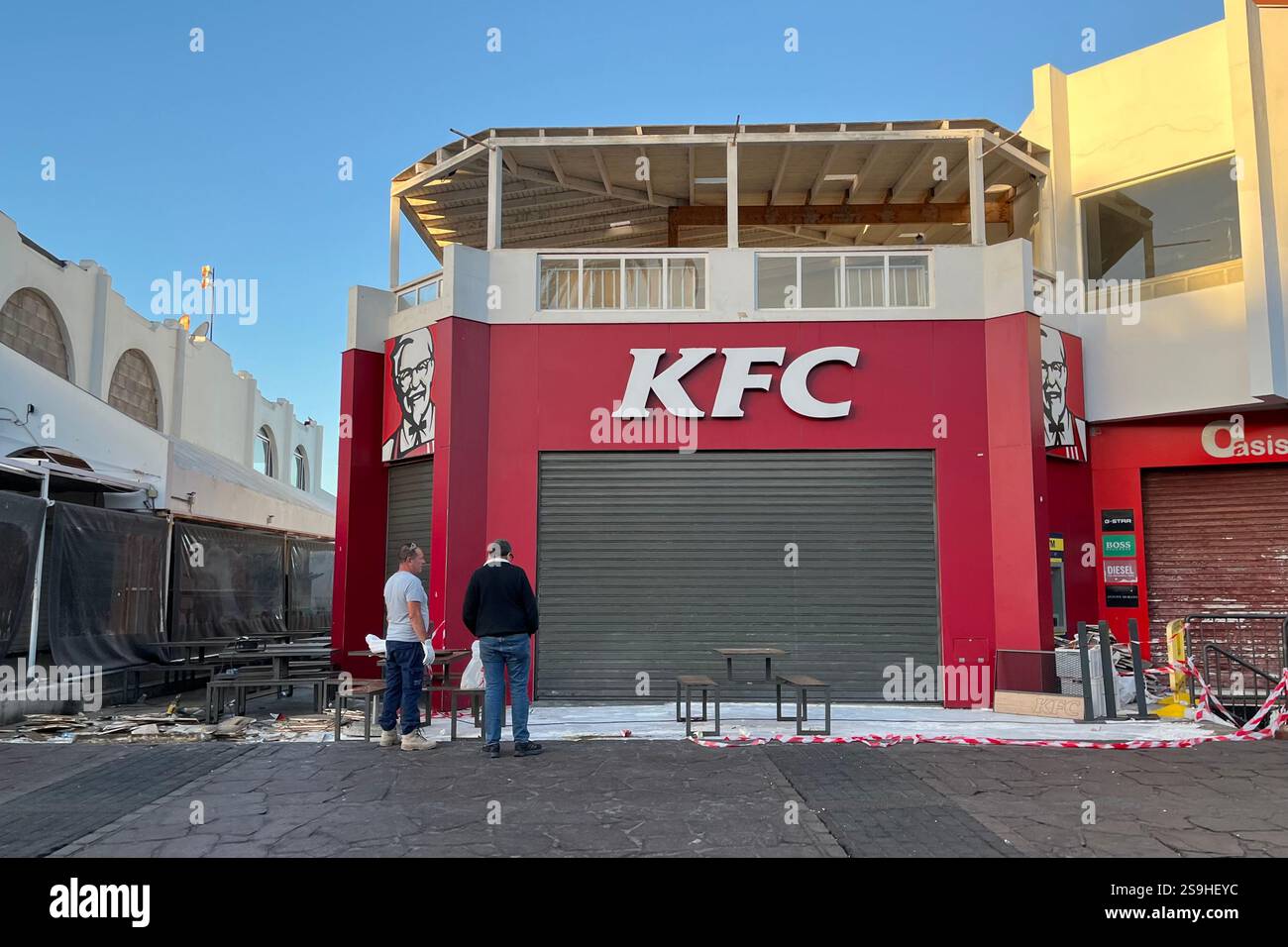 KFC Storefront mit geschlossenen Rollläden und Arbeiten im Freien. Playa de las Américas, Teneriffa, Kanarische Inseln, Spanien. Januar 2025. - Smartphone-aufgenommenes Stockfoto