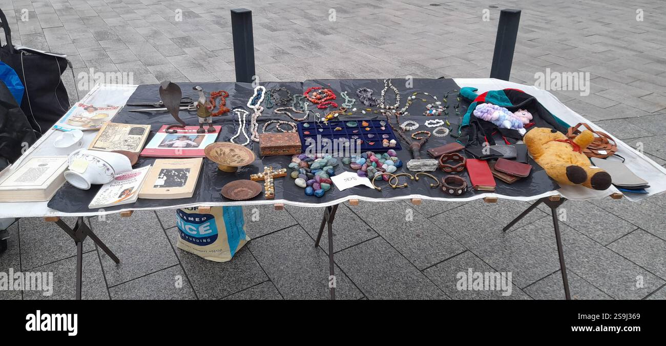 Europäischer Antiquitätenmarkt, Stand am Flohmarkt : farbenfrohe Kristallsteine, Kristallschmuck, Bernsteinketten, Vintage-Spielzeug, Vintage-Bücher, Vintage Rosenkranzperlen, Naturstein- und Mineralhalsketten, Edelsteinanhänger, Vintage Medaillen, Vintage Lederbrieftaschen, Vintage Gusseisenschere, Vintage Lederhandschuhe, Vintage Modeschmuck, Vintage Kreuz Stockfoto