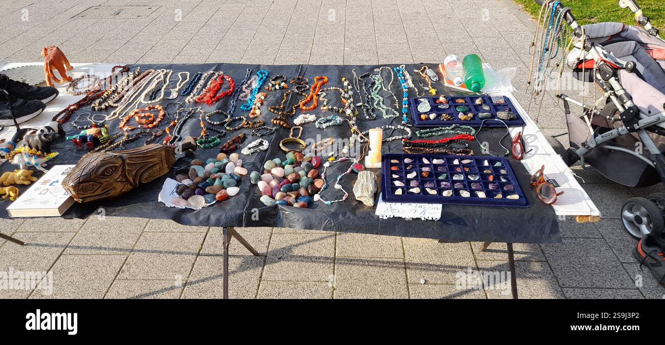 Europäischer Antiquitätenmarkt, Stand am Flohmarkt : farbenfrohe Kristallsteine, Kristallschmuck, Bernsteinketten, Vintage-Spielzeug, Vintage-Bücher, Vintage Rosenkranzperlen , Naturstein und Mineralkette, Edelstein Anhänger, Vintage Lederhandschuhe, Vintage Modeschmuck, Vintage Stein ( Mineralsteine Halbedelsteine ) Kreuz, Messing Armbänder, Kristallarmbänder, Fossilien, Achat, bescheidene Steine aus Rosenquarz, Vintage-Schweinespielzeug, Vintage-T-rex-Spielzeug, massive handgeschnitzte Holzschildkröte / Schildkrötenkopf Stockfoto