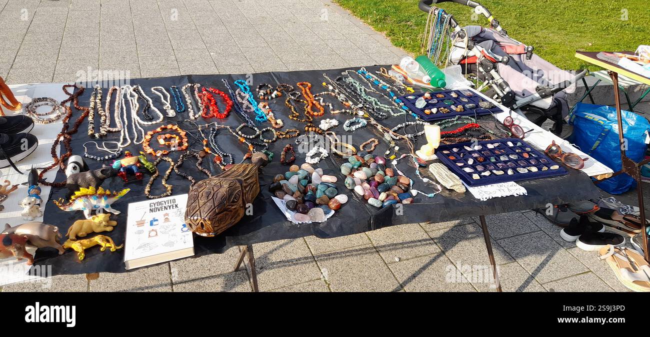 Europäischer Antiquitätenmarkt, Stand am Flohmarkt : farbenfrohe Kristallsteine, Kristallschmuck, Bernsteinketten, Vintage-Spielzeug, Vintage-Bücher, Vintage Rosenkranzperlen , Naturstein und Mineralkette, Edelstein Anhänger, Vintage Lederhandschuhe, Vintage Modeschmuck, Vintage Stein ( Mineralsteine Halbedelsteine ) Kreuz, Messing Armbänder, Kristallarmbänder, Fossilien, Achat, bescheidene Steine aus Rosenquarz, Vintage-Schweinespielzeug, Vintage-T-rex-Spielzeug, massive handgeschnitzte Holzschildkröte / Schildkrötenkopf Stockfoto