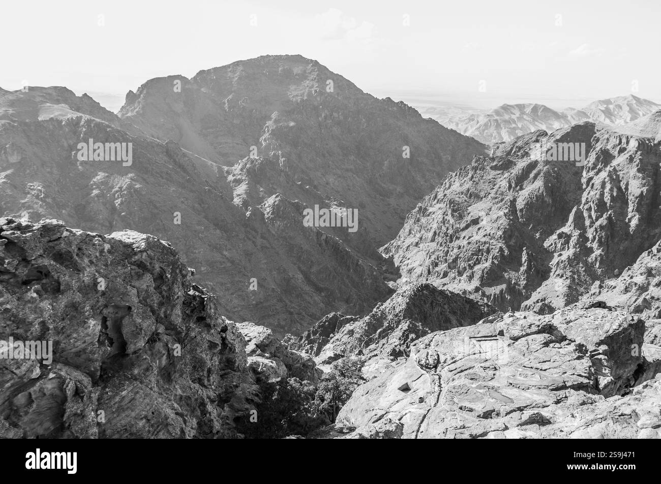Eine Bergkette mit einer felsigen, kargen Landschaft. Der Himmel ist bewölkt und die Berge sind mit Schnee bedeckt Stockfoto