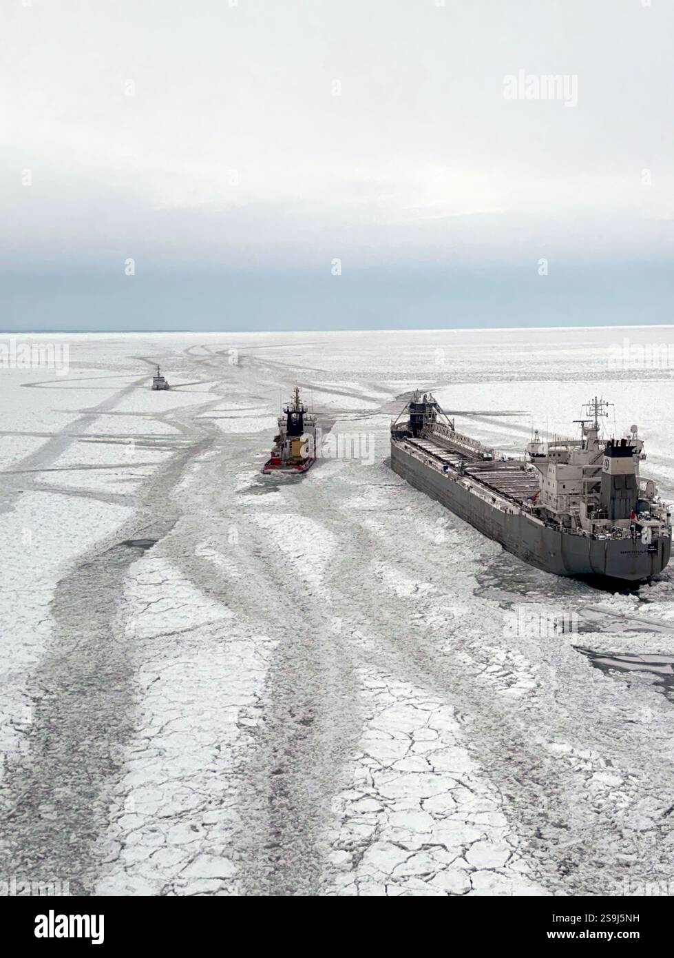 Buffalo, Usa. Januar 2025. Die US-Küstenwache Cutter Neah Bay, links, ein 140 Fuß langer Eisschlepper kommt an, um den See Frachter M. zu befreien V Manitoulin, richtig, gefangen in dickem Eis, 25. Januar 2025 in der Nähe von Buffalo, New York. Das 663-Fuß-Schiff mit 17 Personen an Bord war auf dem Weg nach Kanada, nachdem es eine Ladung Weizen in Buffalo, New York, abgesetzt hatte, als es am 22. Januar in dickem Eis steckte. Quelle: PO3 Omar Faba/US Coast Guard/Alamy Live News Stockfoto