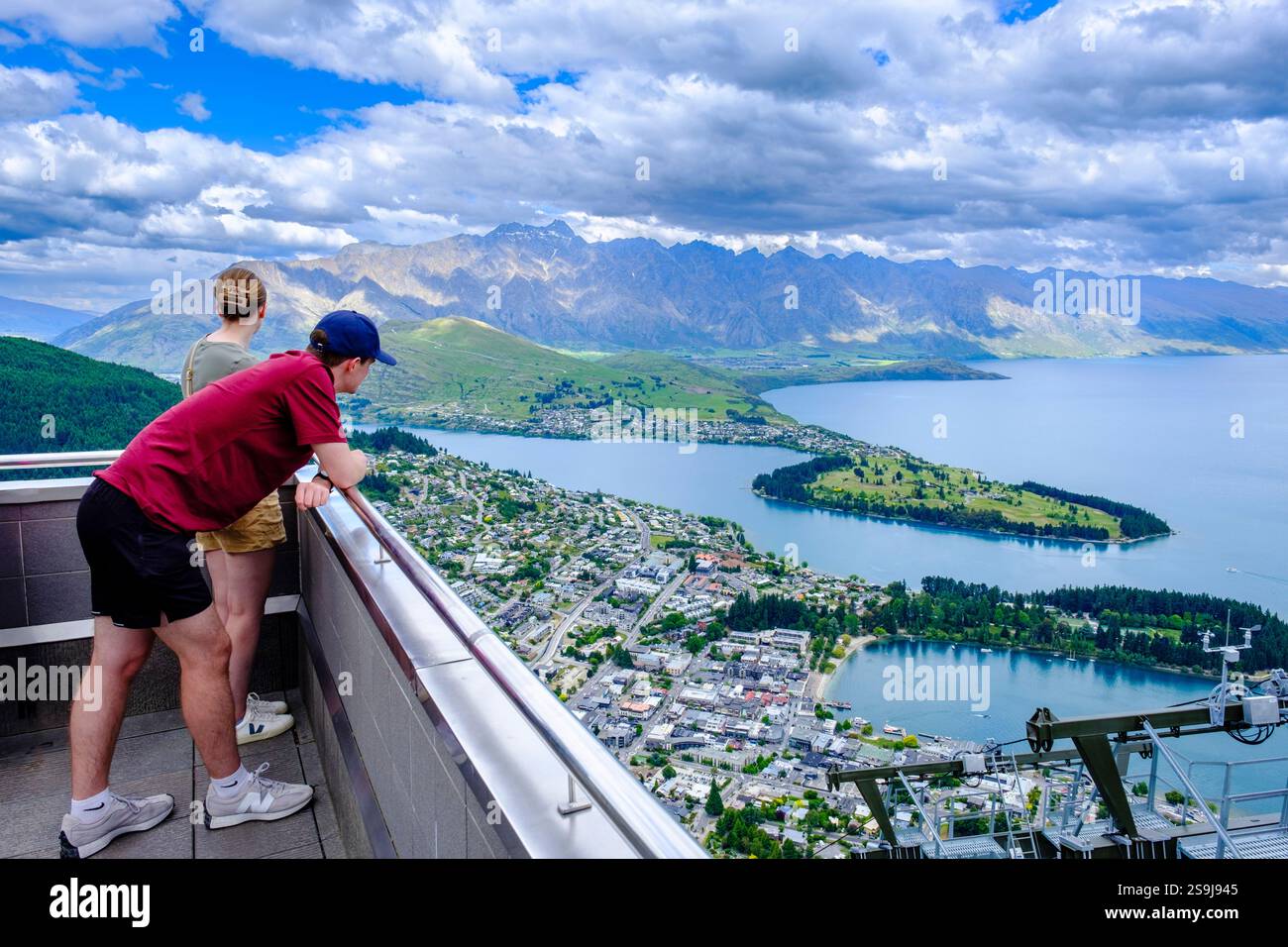 Ein paar Touristen genießen einen Panoramablick auf Queenstown, Lake Wakatipu und die Aussichtsplattform der Skyline Gondel in Neuseeland, Neuseeland Stockfoto