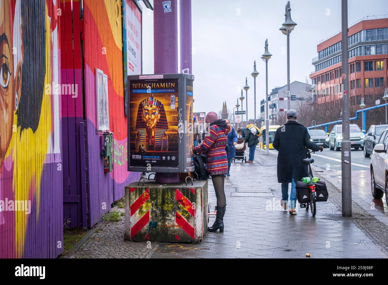 Eine Frau in einem bunten Mantel auf einer Straße in Berlin Stockfoto