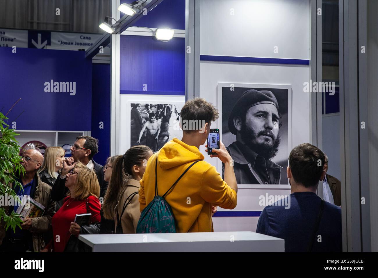 BELGRAD, SERBIEN - 12. OKTOBER 2024: Besucher einer Ausstellung in Belgrad, die Fotografien eines Porträts von Fidel Castro aufnehmen und die Öffentlichkeit in zeigen Stockfoto