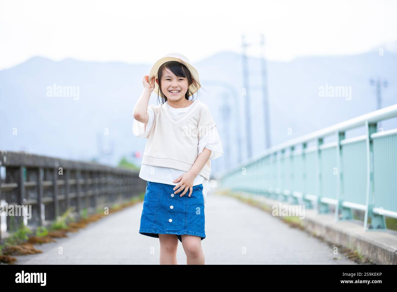 Lächelndes Mädchen mit Strohhut Stockfoto