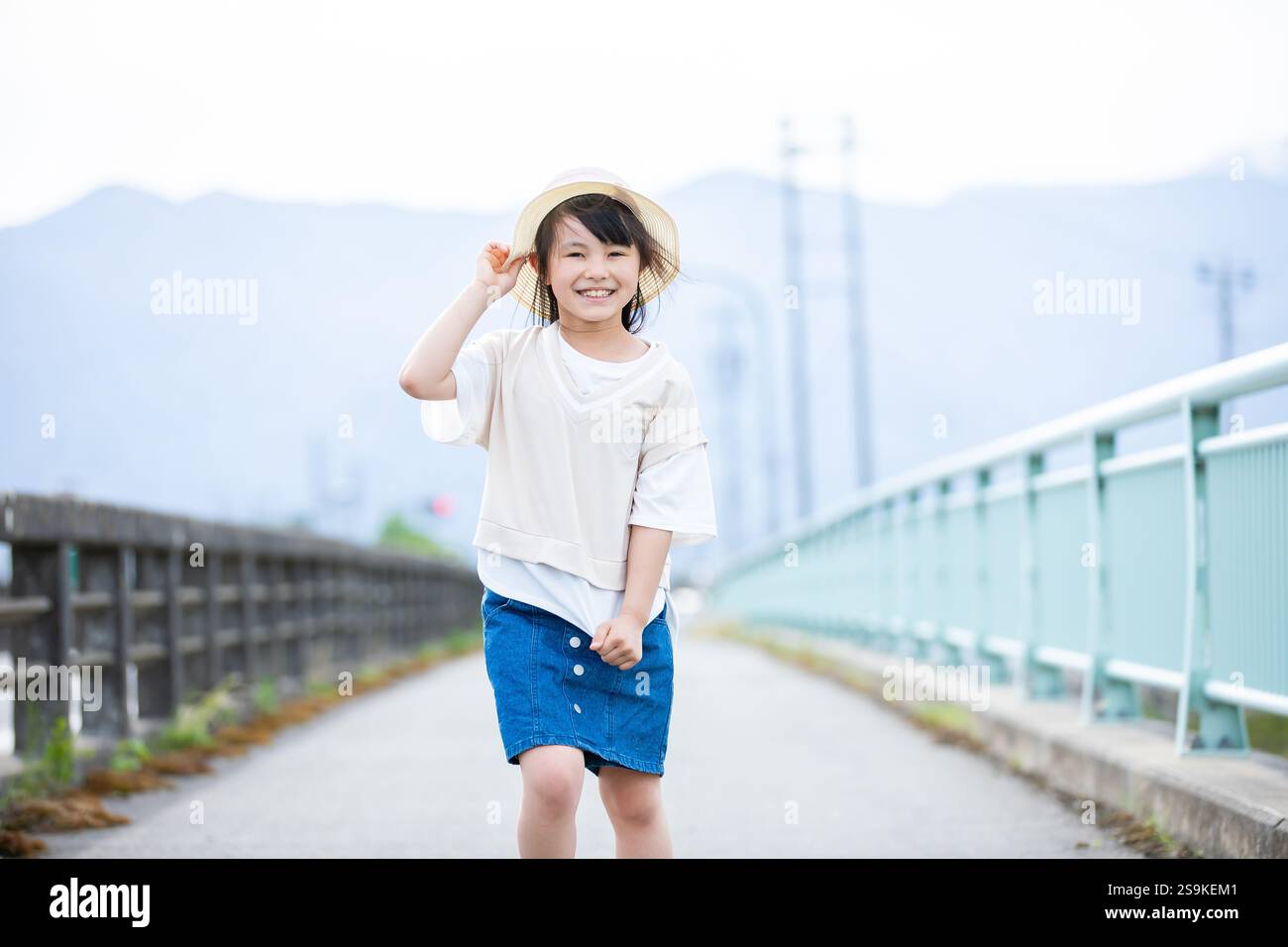 Lächelndes Mädchen mit Strohhut Stockfoto