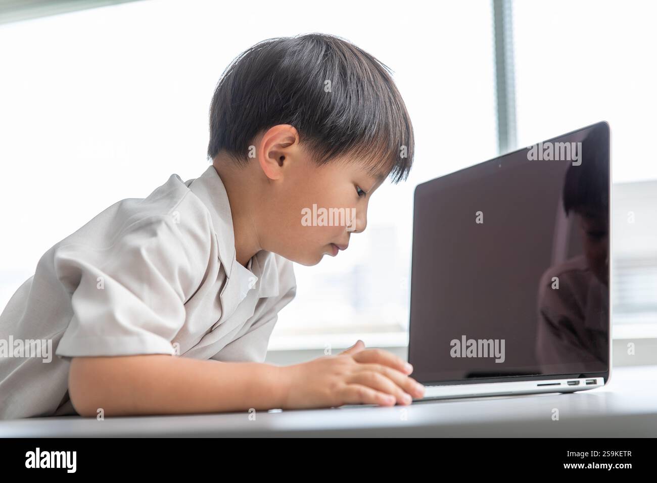 Kind, das einen Computer bedient Stockfoto