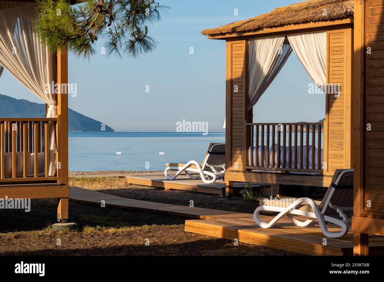 Private Strandhütten an einer ruhigen Sandküste bei Sonnenuntergang Stockfoto