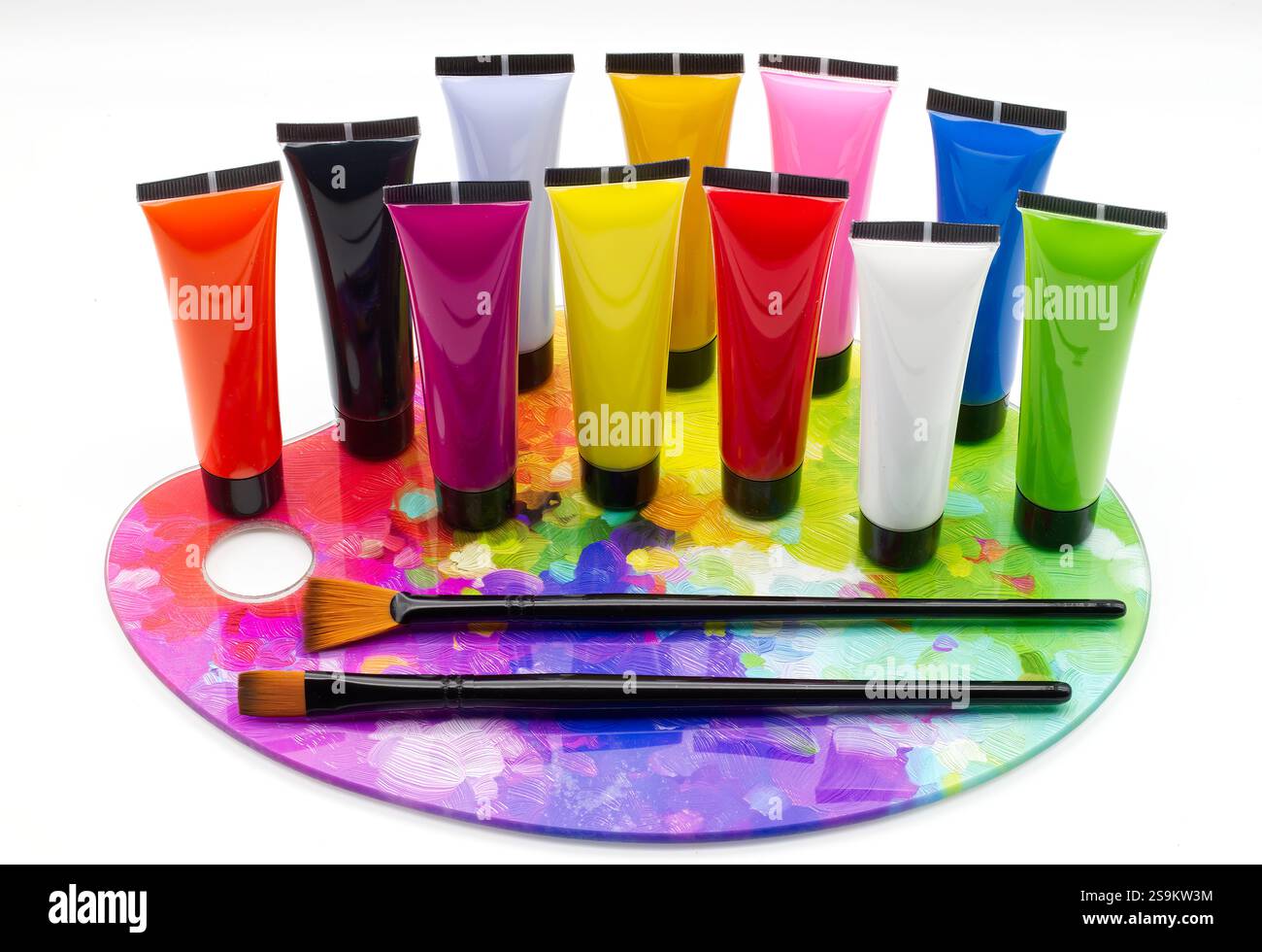 Bunte Farbröhren auf einer Palette mit Pinseln, isoliert auf weißem Hintergrund. Stockfoto
