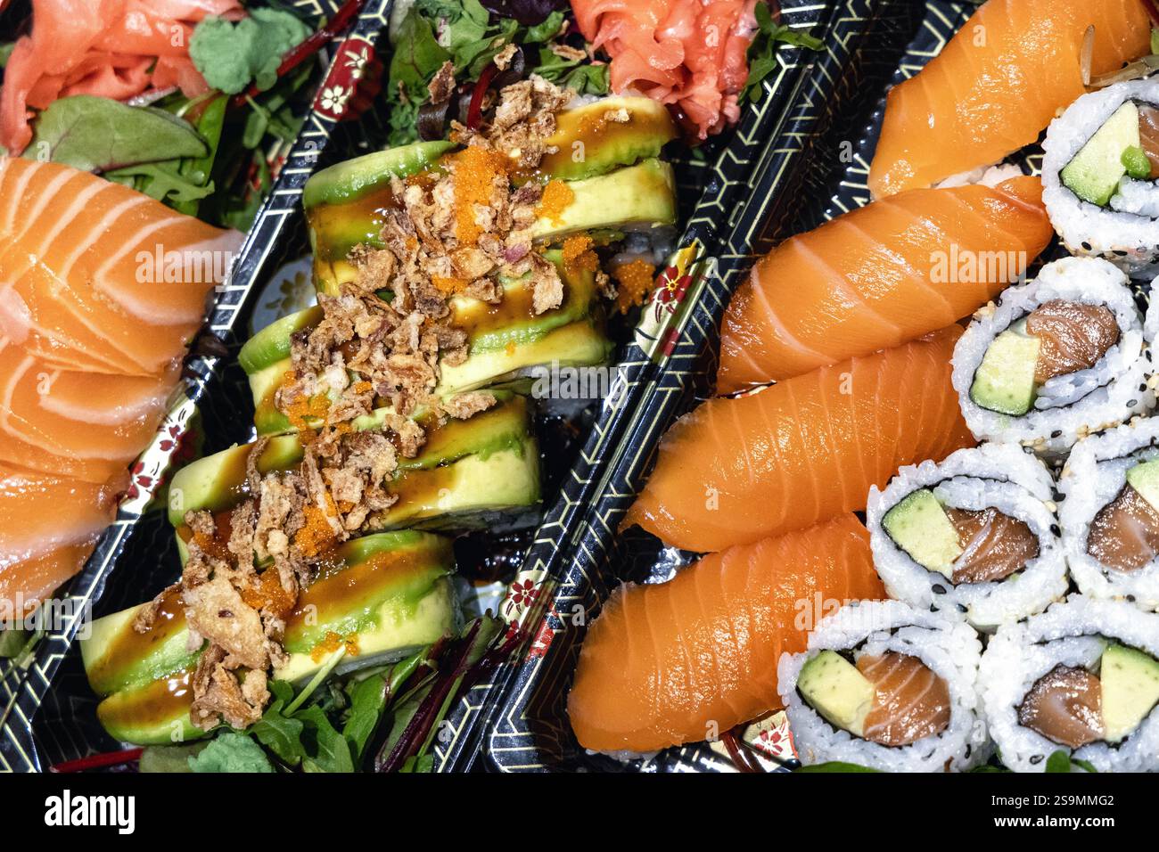 Köstliches japanisches Sushi - Lachnigiri, kalifornische Rolle, Drachenrolle und Sashimi auf Plastiktabletts Stockfoto