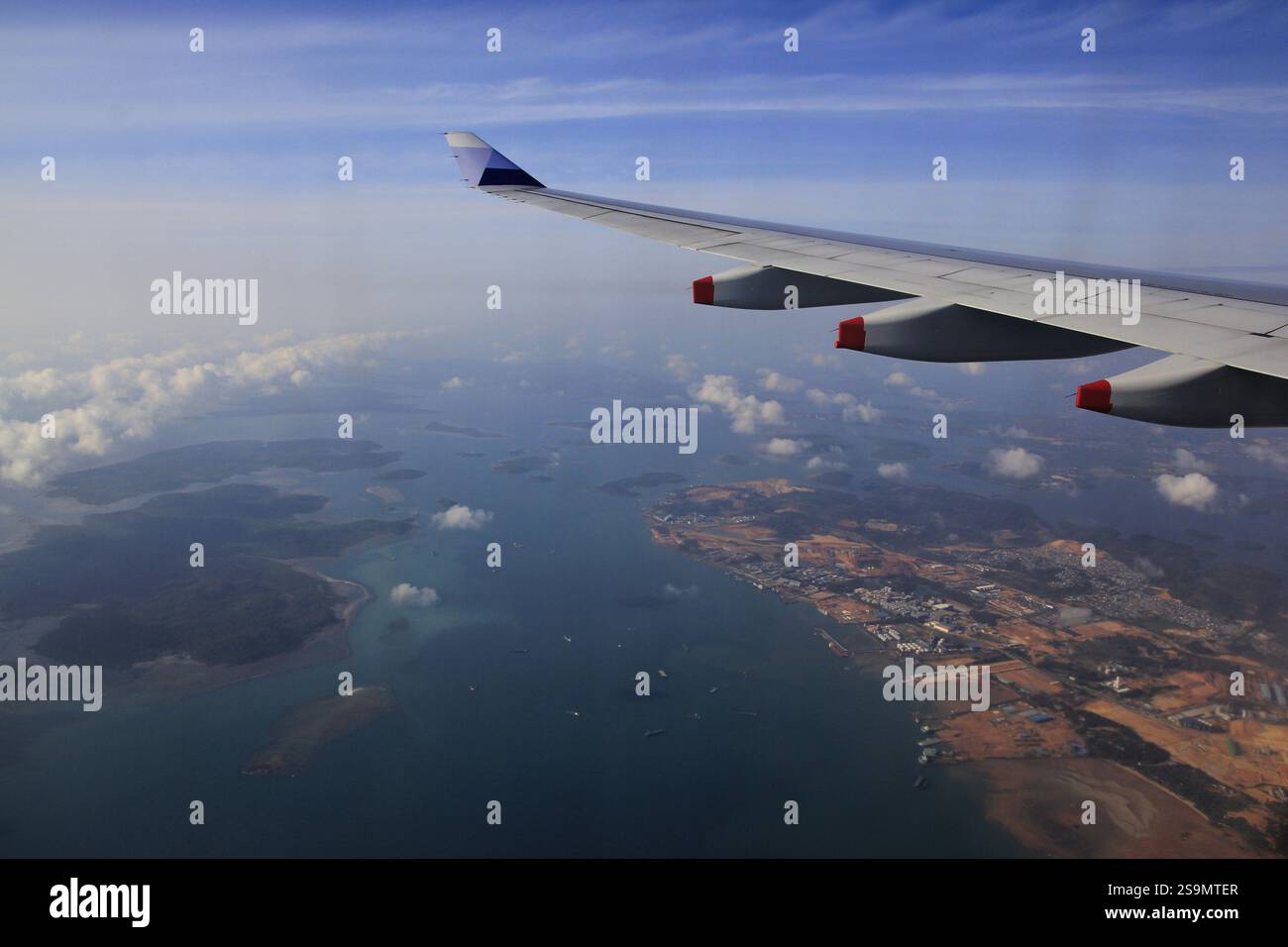Blick aus dem Flugzeugfenster, während es über Batam Island, Riau Islands, Indonesien, die direkt an Singapur grenzt. Stockfoto
