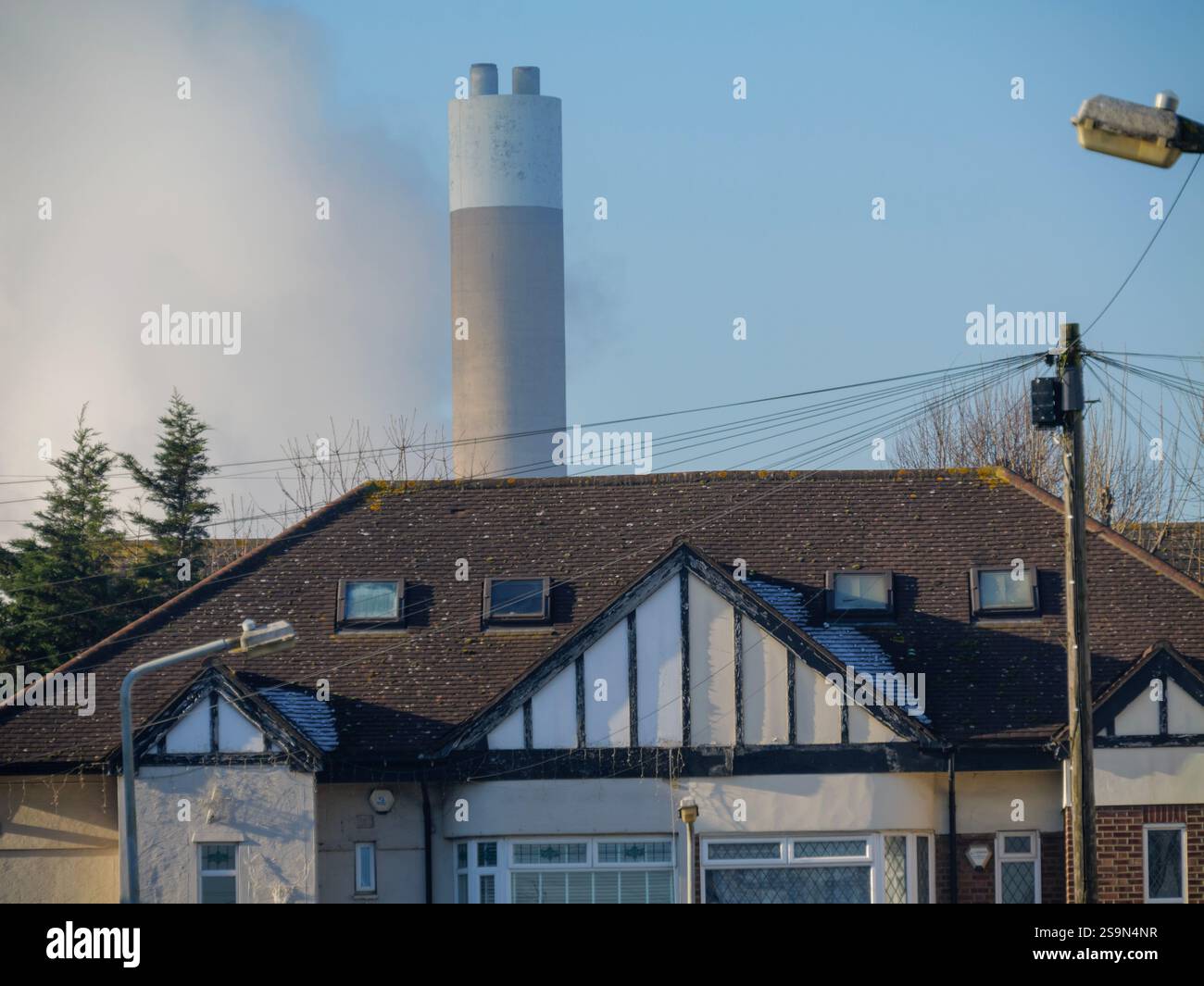 Wohngebäude vor der Verbrennungsanlage Chimney bei Ecopark, einer Müllverbrennungsanlage, die Abfälle aus mehreren Londoner Stadtteilen verbrannt und Strom für das National Grid, Edmonton, Enfield, Großbritannien, liefert Stockfoto