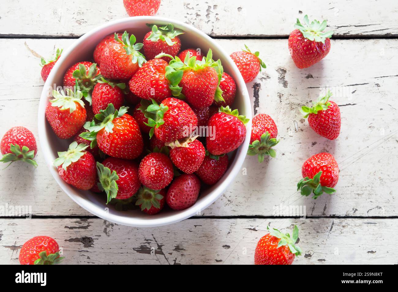 Frische reife Erdbeeren in Schale auf weißem Holztisch, Sommerfrüchte, Erdbeere ( Fragaria Stockfotografie