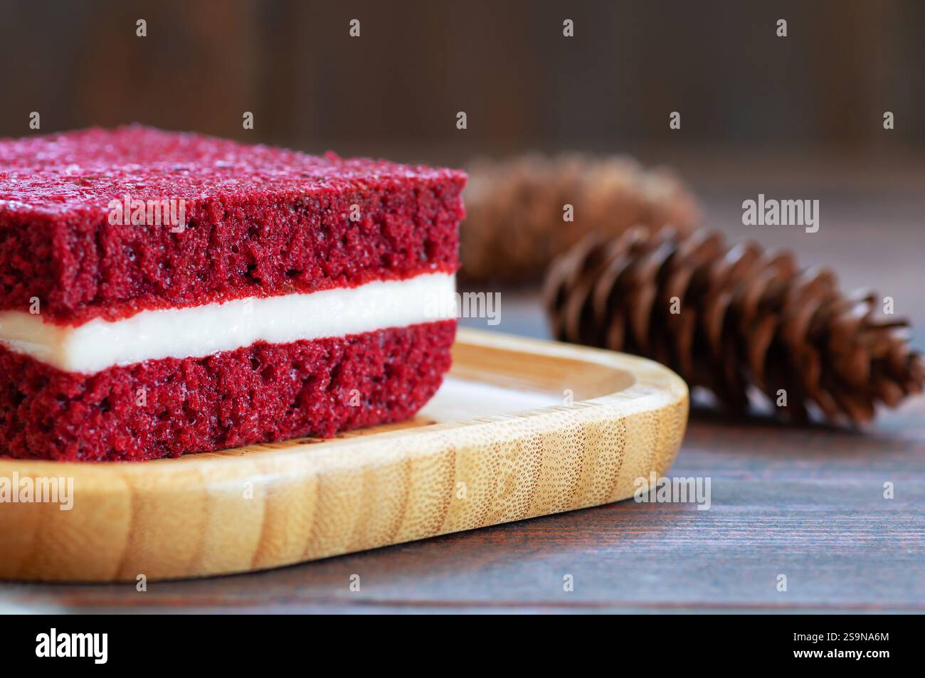 Stück roten Samtkuchen in Teller auf rustikalen Tisch, quadratisch geschnitten, kopieren Raum selektiven Fokus Stockfoto