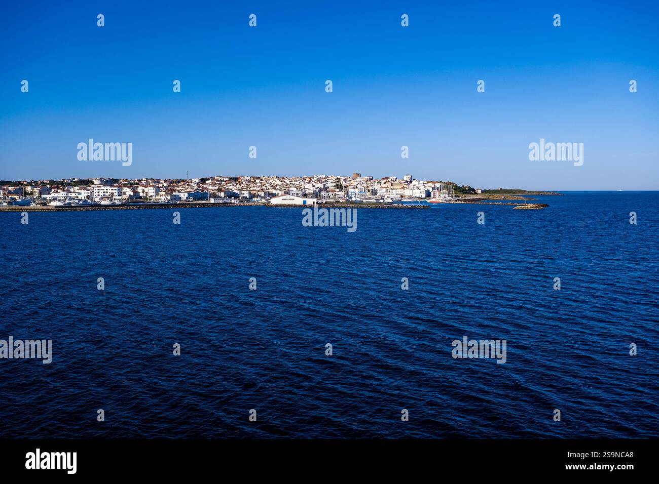 Häuser der Küstenstadt Calasetta, von einer Fähre aus gesehen über das Mittelmeer. Stockfoto