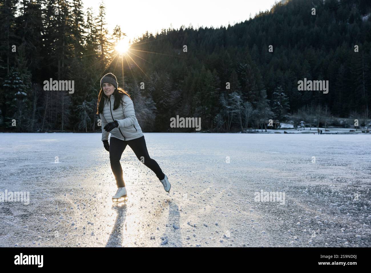 Winterszene eines Skaters, der die Natur auf einem gefrorenen See genießt. Stockfoto