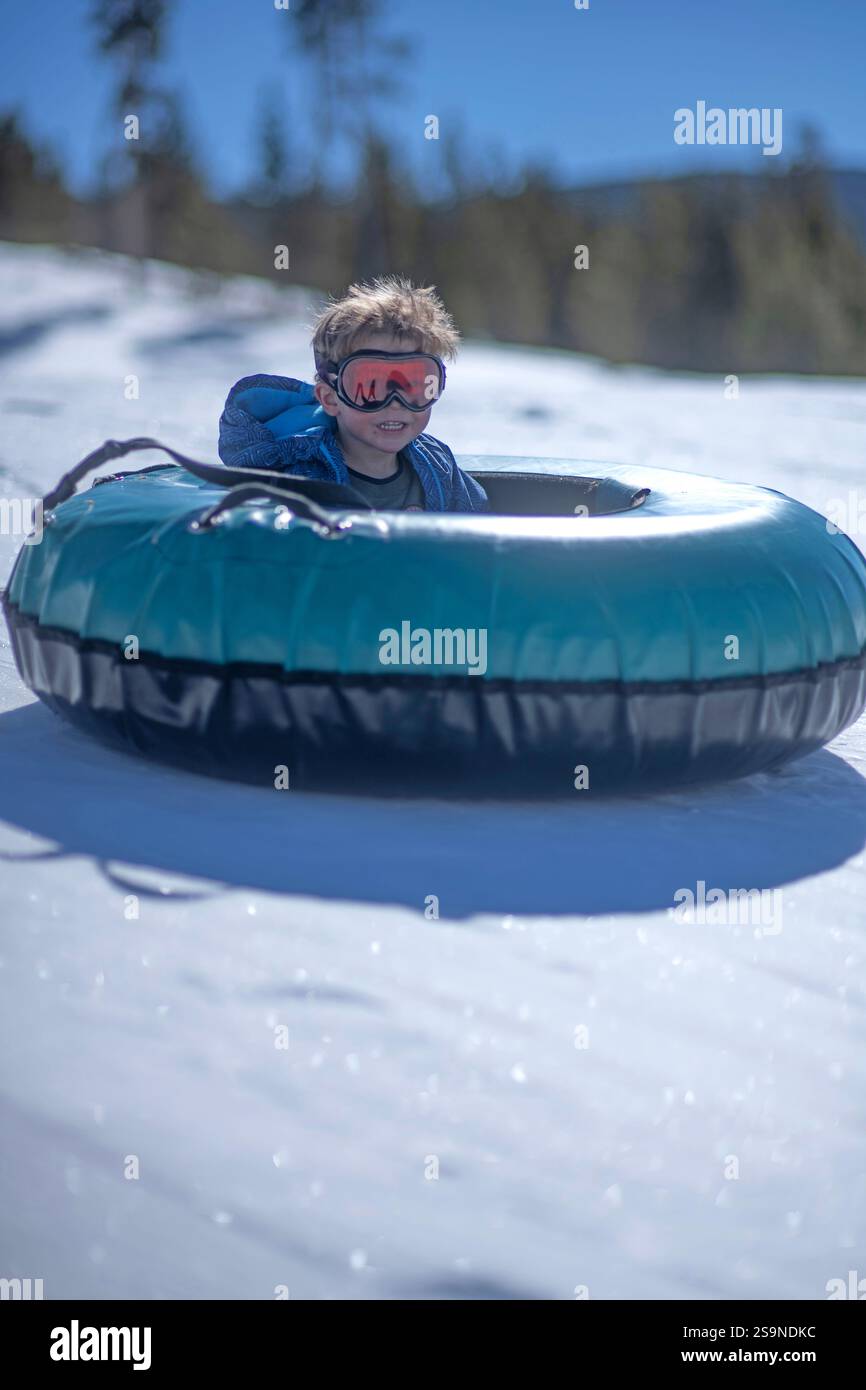 3 YO Boy Snowtubes alleine bergab in Colorado. Stockfoto