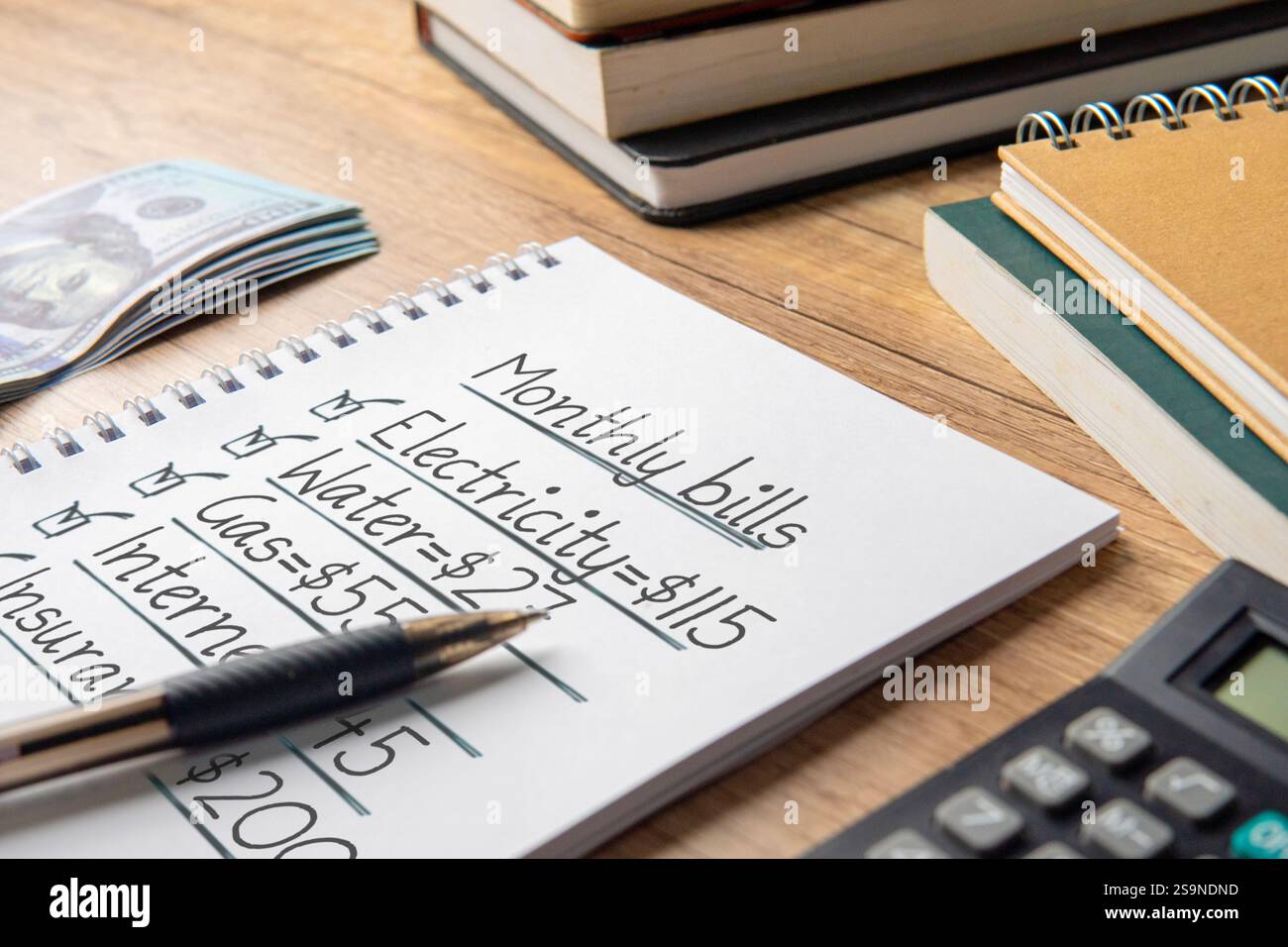 Ein Nahbild eines Notizbuchs mit einer handgeschriebenen Monatsabrechnungsliste. Haushaltsbudgetplanung und persönliches Finanzmanagement. Stockfoto