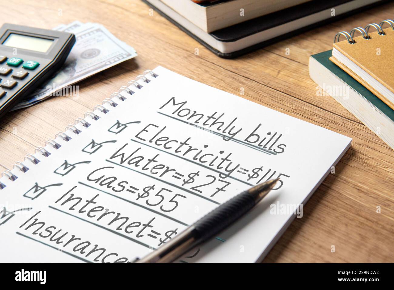 Ein Nahbild eines Notizbuchs mit einer handgeschriebenen Monatsabrechnungsliste. Haushaltsbudgetplanung und persönliches Finanzmanagement. Stockfoto