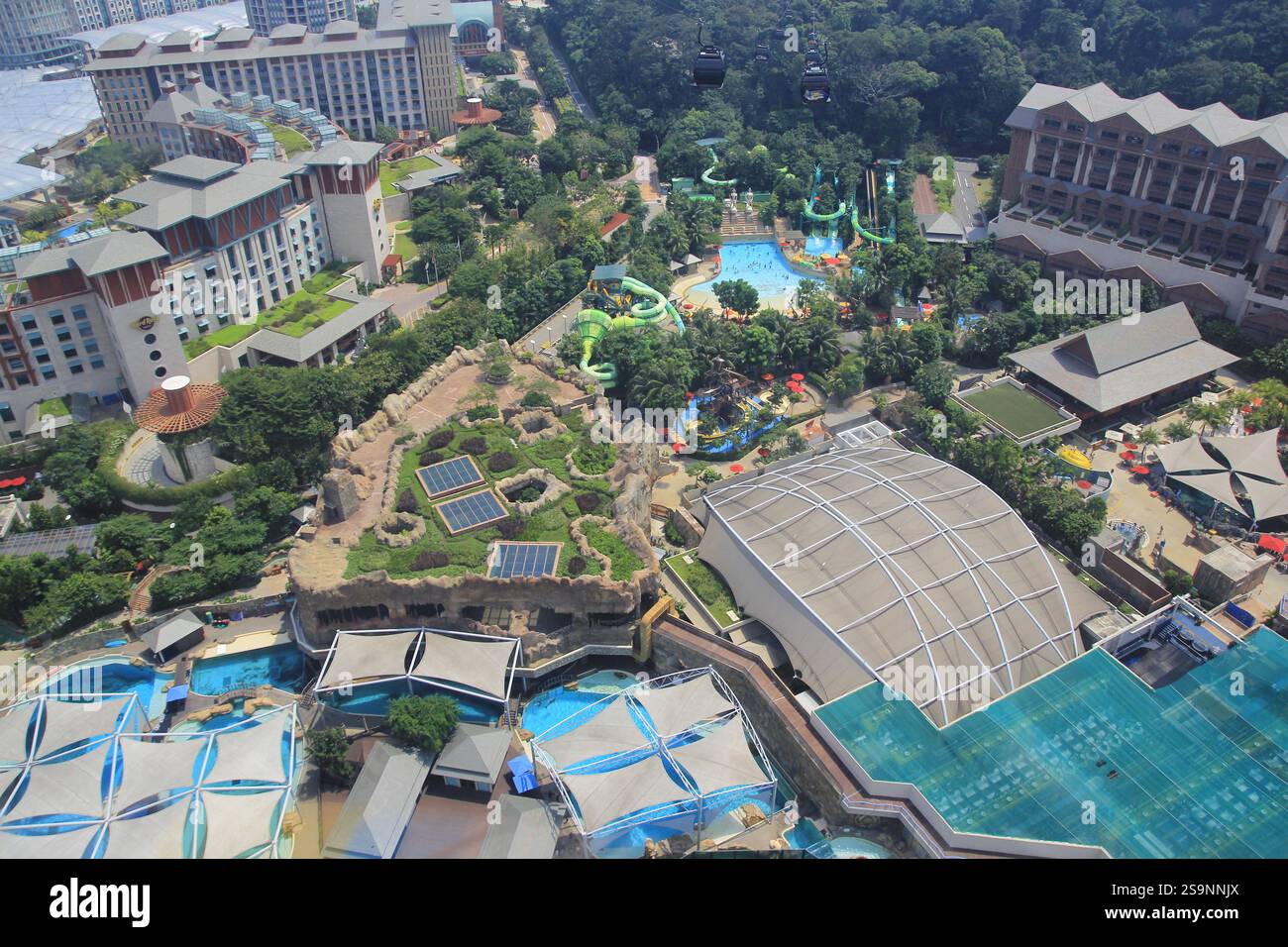 Blick aus der Vogelperspektive auf die Touristengegend der Insel Sentosa, die mit Wasserfahrten gefüllt ist Stockfoto