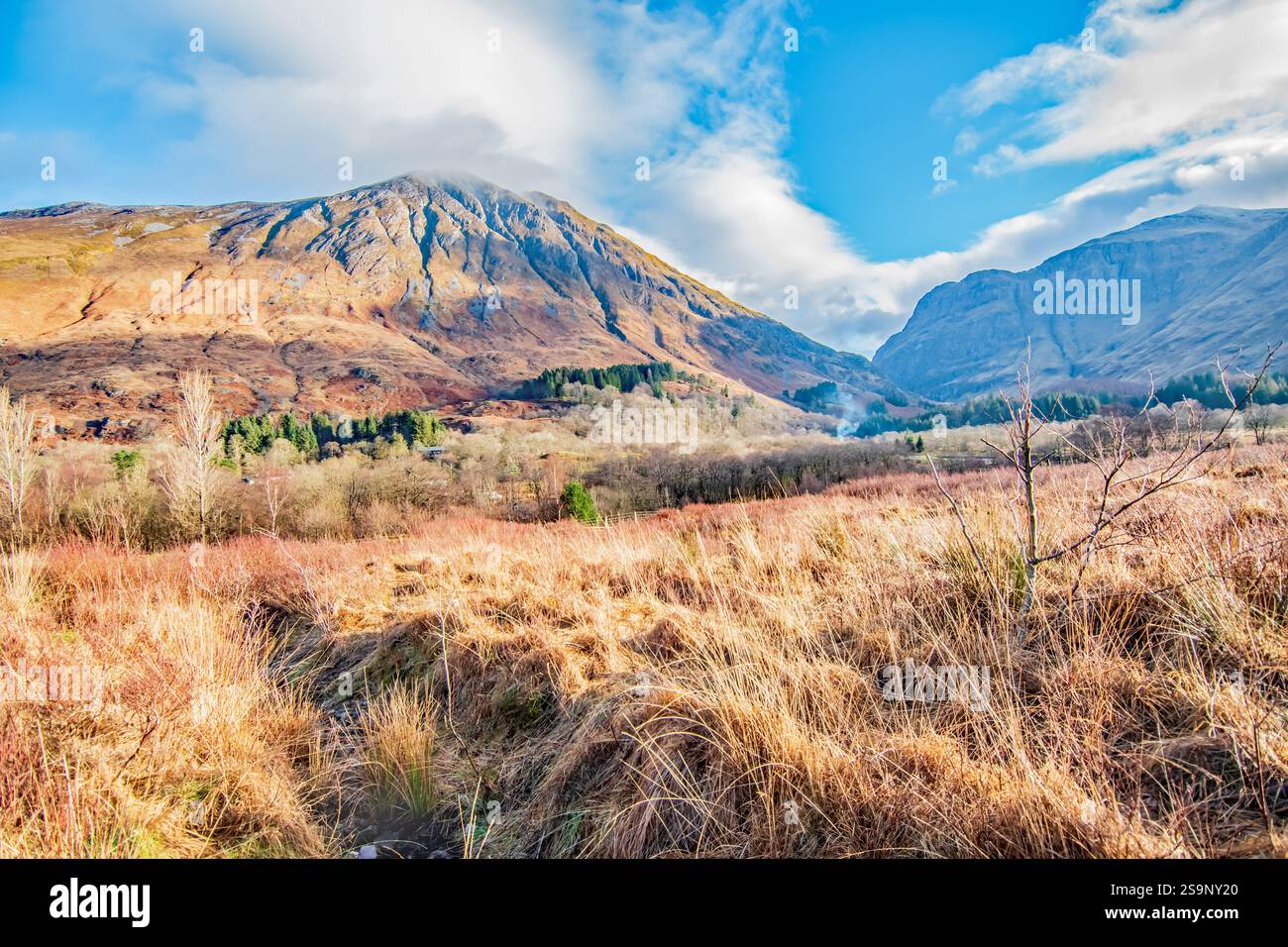 Über die Winterwiese zu den farbenfrohen Glencoe Hills und Blue Sky Stockfoto