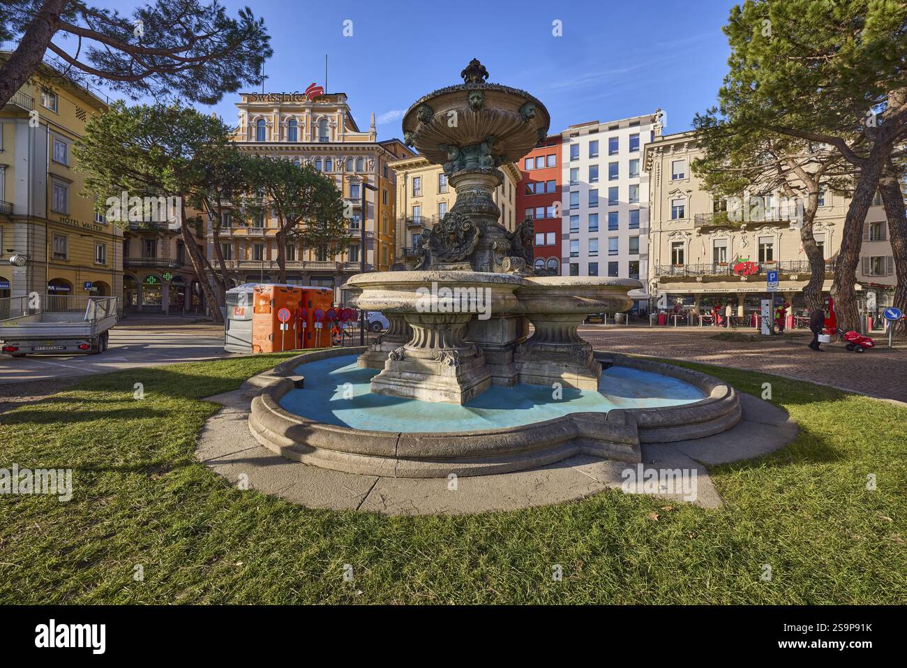 Brunnen, Fontana Antonio Bossi, Rasen, allgemeine Architektur, Bäume, blauer Himmel, Straße Riva Vincenzo Vela, Lugano, Bezirk Lugano, Kanton Tessin, Switz Stockfoto