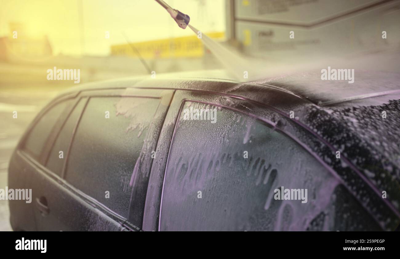 Autodach waschen bei Sonnenuntergang mit Schaum, Seifenspray für einen rosafarbenen Farbton Stockfoto