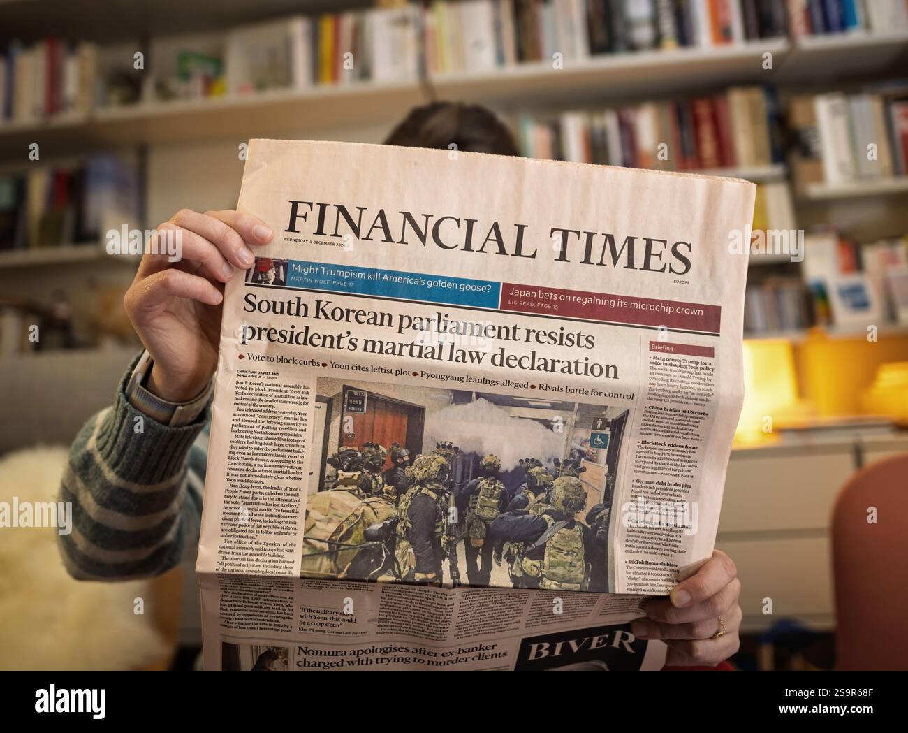 Paris, Frankreich - 9. Dezember 2024: Eine Person, die die Financial Times liest, mit einer Titelzeile über das südkoreanische parlament, das sich dem Präsidenten widersetzt Stockfoto