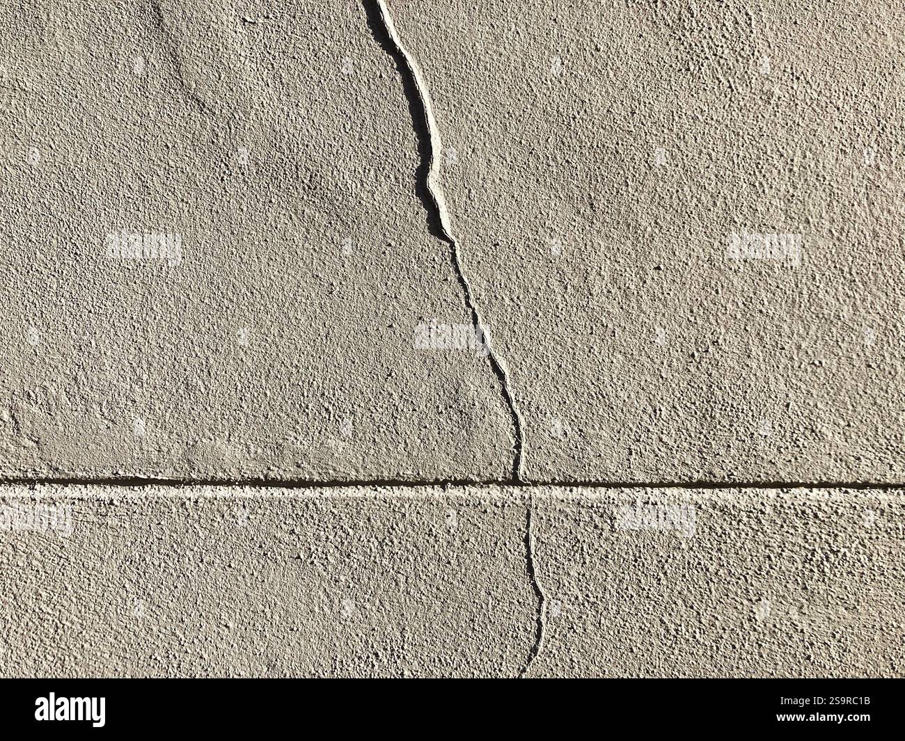 Detaillierte Textur einer gerissenen Betonwand, die die Feinheiten der Oberfläche und ihre Mängel zeigt. - Smartphone-aufgenommenes Stockfoto