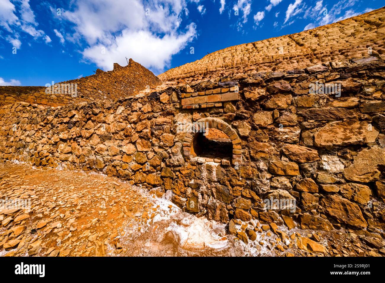 Orangefarbene Halden von Monteponi, einst eines der größten Bergbaugebiete Sardiniens. Stockfoto